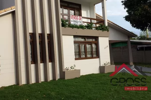 Casa a venda medindo 230m², toda murada, possui uma suíte com sacada e banheiro com hidromassagem, 2 quartos, sala de tv com lareira, sala de jantar e estar, lavanderia, despensa, adega, área com churrasqueira com quarto e banheiro.