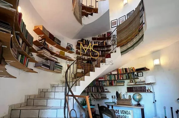 Biblioteca com estantes circulares que acompanham uma escada caracol