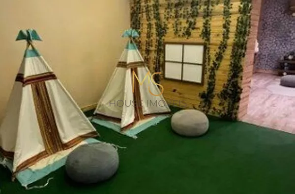 Linda brinquedoteca lúdica com cabanas, mini cozinha e brinquedos.
