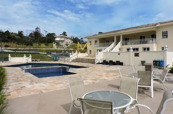 Muitas mesas e cadeiras na área da piscina para pegar um sol e aproveitar a paisagem