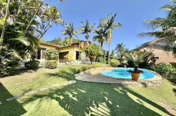 Vista do jardim, com a piscina e a casa ao fundo