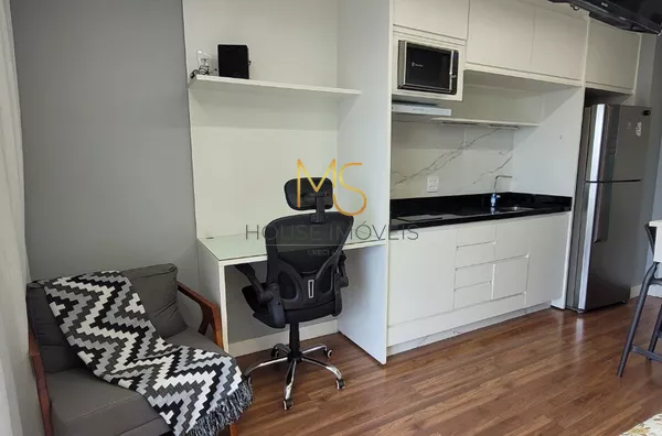 Área para trabalho, com mesa, cadeira e uma poltrona de apoio.
