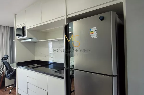 Cozinha equipada com armários planejados, geladeira, fogão de indução de duas bocas, depurador de ar e microondas