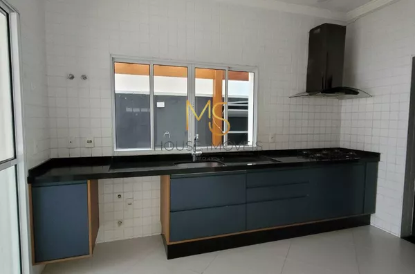 Cozinha com armários planejados, cooktop, coifa e espaço para lava-louças de 14 serviços