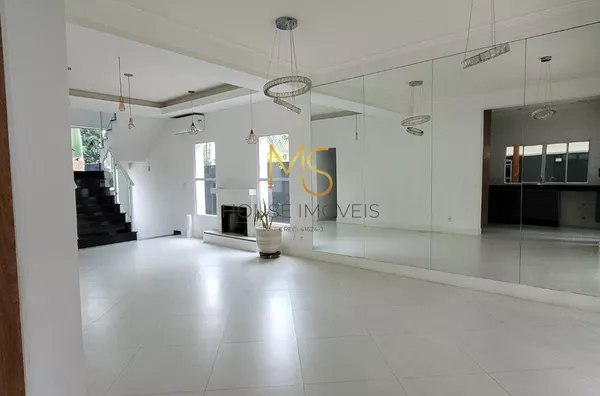 Sala de lareira e sala de jantar, com espelhos e lustres