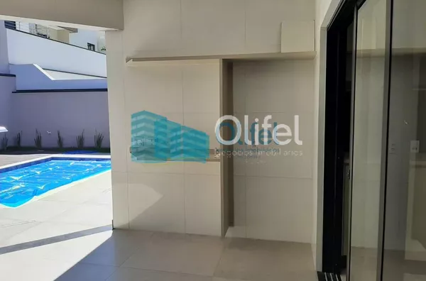 Linda casa térrea, 206m².O imóvel conta com 03 suítes com armários, sendo a suíte master com closet, escritório, lavabo, sala 2 ambientes, cozinha com armários e espaço gourmet com churrasqueira e armários, fogão cooktop  ja instalado. Piscina Aquecida. T - Foto 4